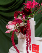 Decorative floral arrangement on a chair with a green curtain background