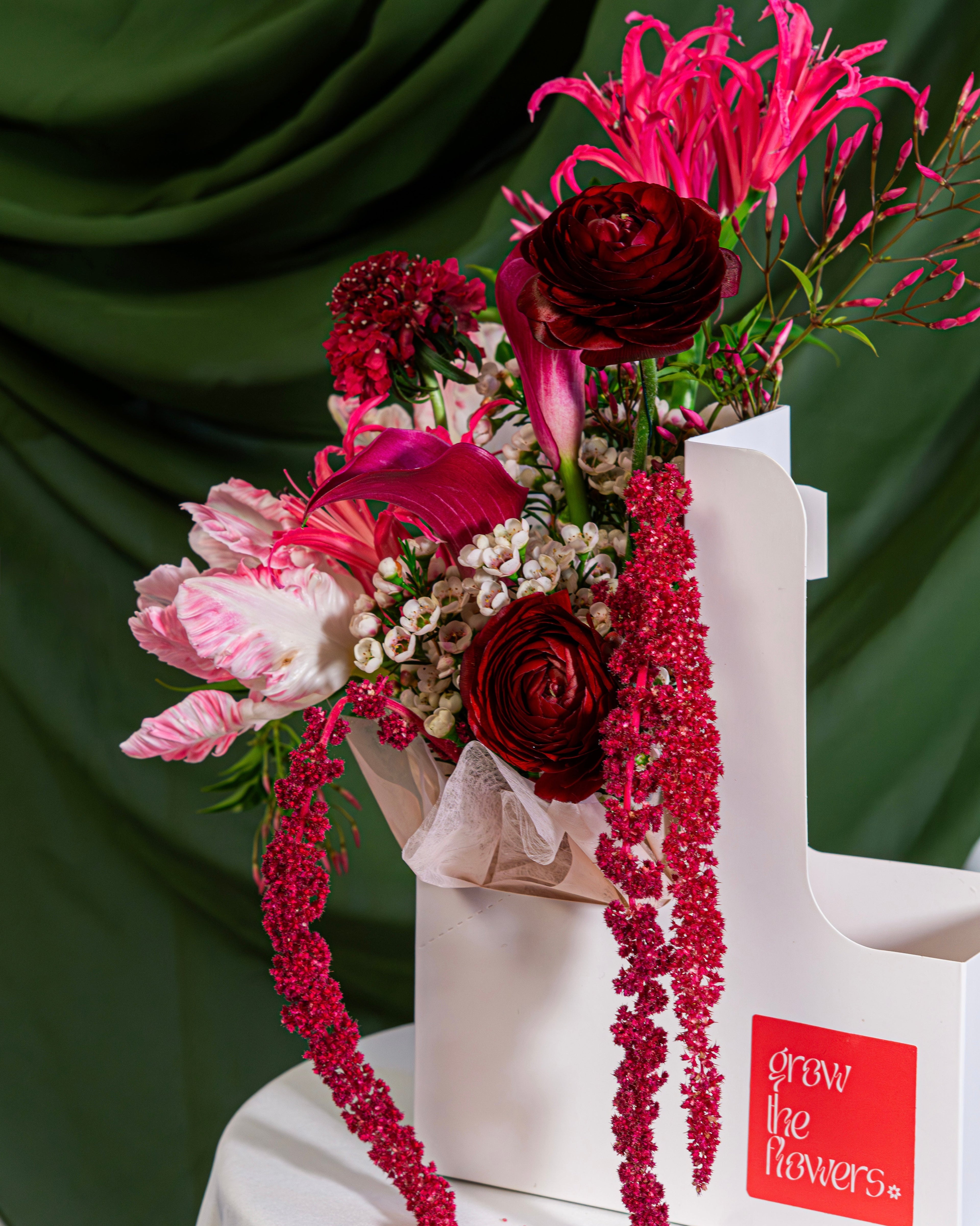 Decorative floral arrangement on a chair with a green curtain background